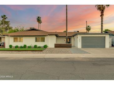 Charming single story home with a modern gray garage door at 8247 E Devonshire Ave, Scottsdale, AZ 85251