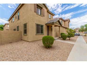 Two story tan house with landscaping and a walkway at 915 E Agua Fria Ln, Avondale, AZ 85323