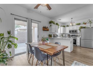 Modern kitchen with white cabinets and a wooden dining table at 2300 E Magma Rd # 160, San Tan Valley, AZ 85143