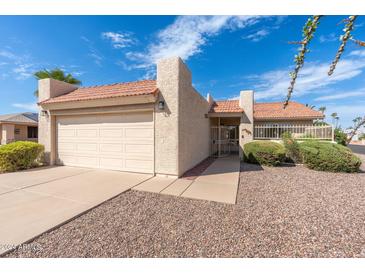 Single story home with attached garage and desert landscaping at 9614 E Bud Ct, Sun Lakes, AZ 85248