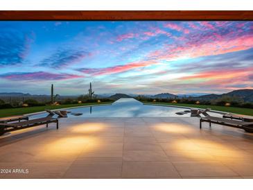 Infinity pool with mountain views at sunset at 42515 N 102Nd St, Scottsdale, AZ 85262