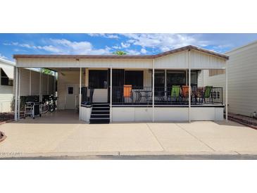 Mobile home exterior with covered deck and seating area at 17200 W Bell Rd # 569, Surprise, AZ 85374
