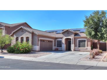 House exterior featuring a two-car garage and solar panels at 1594 E Desert Breeze Dr, Casa Grande, AZ 85122
