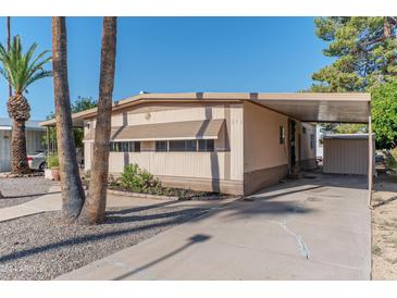 Front view of a manufactured home with carport, landscaping, and storage shed at 2650 W Union Hills Dr # 236, Phoenix, AZ 85027