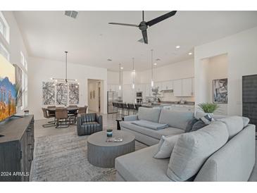 Open living room with large TV, comfortable seating, and kitchen views at 38500 N School House Rd # 5, Cave Creek, AZ 85331