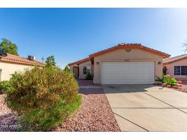 Tan house with white garage door and landscaping at 4545 N 67Th Ave # 1242, Phoenix, AZ 85033