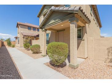 Tan two-story house with front walkway, landscaping, and a covered entryway at 812 E Agua Fria Ln, Avondale, AZ 85323