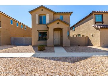 Two-story house with light brown exterior, walkway, and small front yard at 851 E Agua Fria Ln, Avondale, AZ 85323