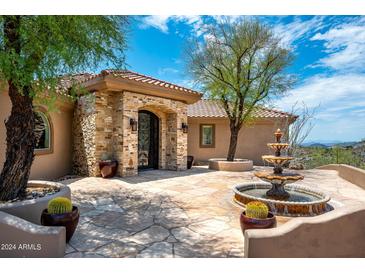 Elegant home entrance with stonework and fountain at 40740 N Longhorn Dr, Scottsdale, AZ 85262