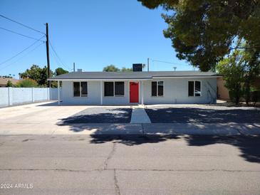 Newly renovated single story home with red door and gray rock landscaping at 1437 E Wesleyan Dr, Tempe, AZ 85282