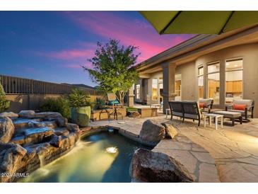 Relaxing backyard oasis with a sparkling pool and waterfall feature at 7755 E Evening Glow Dr, Scottsdale, AZ 85266