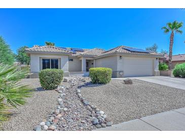 Single story home with a landscaped front yard and solar panels at 15574 W Vista Grande Ln, Surprise, AZ 85374