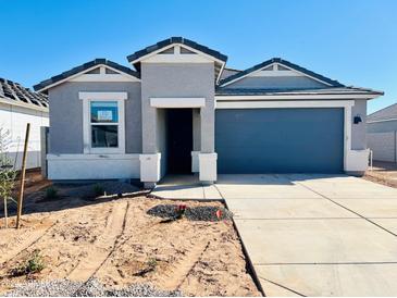 New single-story home with gray exterior and two-car garage at 12253 E Aster Ln, Florence, AZ 85132