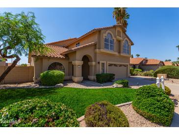 Two-story house with a large front yard, two-car garage, and Spanish-style roof at 5725 E Evans Dr, Scottsdale, AZ 85254