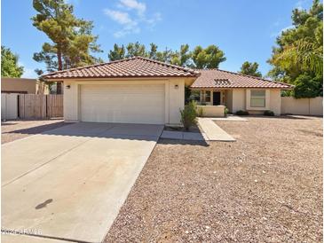 Single-story home with a two-car garage and desert landscaping at 4801 E Nisbet Rd, Scottsdale, AZ 85254