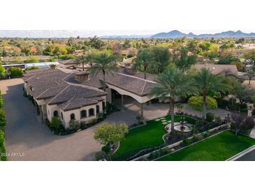 Luxury estate home with expansive grounds, multiple wings, and a large motor court at 9705 E Cholla St, Scottsdale, AZ 85260