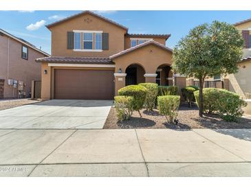 Two-story house with brown exterior, attached garage, and landscaping at 21243 W Coronado Rd, Buckeye, AZ 85396
