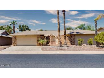 Brick ranch-style home with a courtyard entry and mature palm trees at 19434 N 130Th Ave, Sun City West, AZ 85375