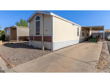 Mobile home with carport, ramp, and gravel driveway at 501 E Ray Rd # 211, Chandler, AZ 85225