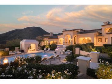 Luxury estate with a large pool, outdoor seating, and mountain views at 10947 E Wingspan Way, Scottsdale, AZ 85255