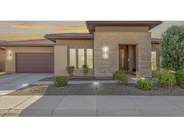 Modern home's exterior features stone accents and a two-car garage at 30056 N 132Nd Dr, Peoria, AZ 85383