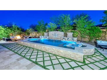 Expansive backyard oasis with a large pool and fire pit at 12789 W Via Caballo Blanco --, Peoria, AZ 85383