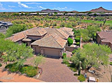 Luxury home with tile roof, large driveway, and desert landscaping at 34617 N Desert Ridge Dr, Scottsdale, AZ 85262