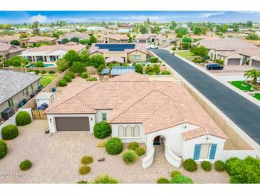 Single-story home with a large backyard, solar panels, and a paved driveway at 1312 E Via Sicilia Rd, San Tan Valley, AZ 85140