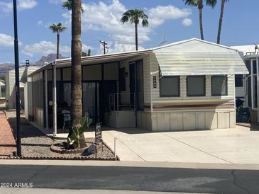 Single-wide mobile home with carport and palm trees at 1289 S Sioux Dr, Apache Junction, AZ 85119