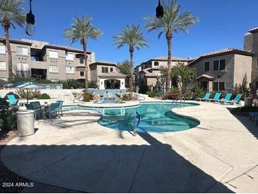 Community pool with lounge chairs and surrounding landscaping at 3236 E Chandler Blvd # 1033, Phoenix, AZ 85048