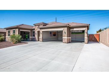 A charming house exterior featuring a three-car garage and attractive landscaping at 43856 N Hudson Trl, New River, AZ 85087