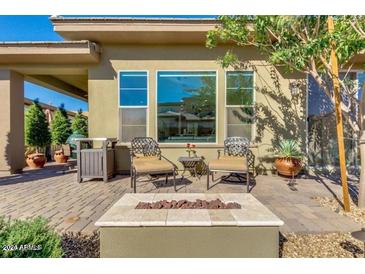 Backyard patio with fire pit and comfortable seating at 36131 N Desert Tea Dr, Queen Creek, AZ 85140