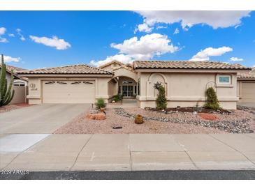 Tan two-story house with a two-car garage and desert landscaping at 14194 W Mountain Laurel Trl, Surprise, AZ 85374