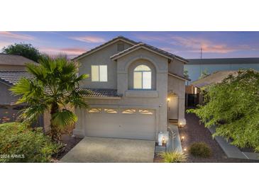 Two story house with tan exterior, two car garage and landscaping at 3211 E Kerry Ln, Phoenix, AZ 85050