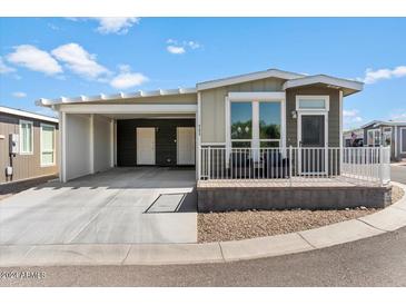 Mobile home with carport, modern exterior, and small front yard at 8865 E Baseline Rd # 753, Mesa, AZ 85209