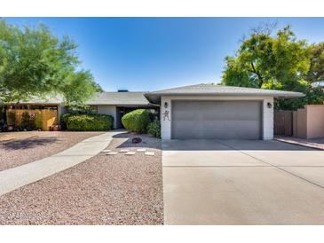 Front view of house with gray garage door at 5013 E Mesquite Wood Ct, Phoenix, AZ 85044