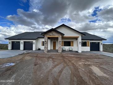 Modern two-story home with stone accents and a three-car garage at 0 W Pima Rd, Maricopa, AZ 85139