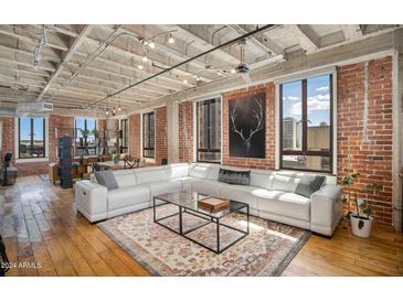 Open living area with exposed brick and large windows at 114 W Adams St # 808, Phoenix, AZ 85003