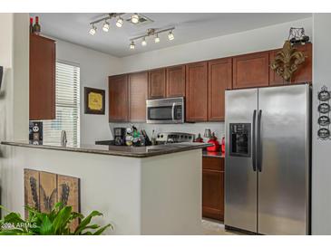 Kitchen with dark wood cabinets, granite counters, and stainless steel appliances at 240 W Juniper Ave # 1241, Gilbert, AZ 85233