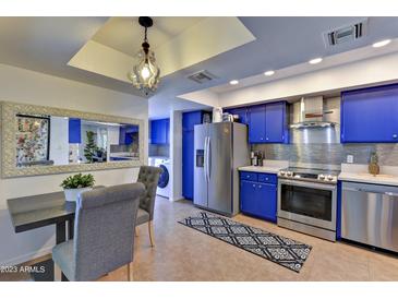 Modern kitchen with blue cabinets and stainless steel appliances at 4525 N 66Th St # 48, Scottsdale, AZ 85251