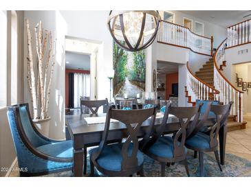 Elegant dining room with a large table, statement lighting, and open staircase at 161 N Silverwood Dr, Casa Grande, AZ 85122