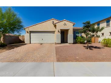 Tan two-story house with a two-car garage and landscaped yard at 17986 W Fulton St, Goodyear, AZ 85338