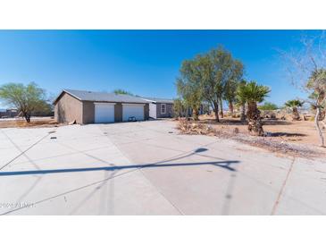 House exterior showcasing a two-car garage and desert landscaping at 3718 S 379Th Ave, Tonopah, AZ 85354