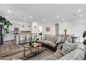 Open living room and kitchen with an island and seating at 22698 E Saddle Way, Queen Creek, AZ 85142