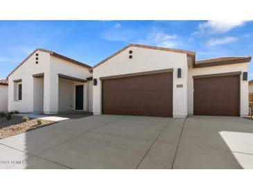 Two-car garage and front elevation of a modern home with desert landscaping at 37735 W Padilla St, Maricopa, AZ 85138