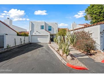 Charming two-story home with white stucco, attached garage, and desert landscaping at 5810 N 8Th Pl, Phoenix, AZ 85014