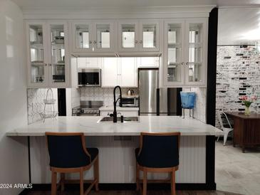 Modern kitchen with white cabinets, marble countertops, and stainless steel appliances at 3119 W Cochise Dr # 225, Phoenix, AZ 85051