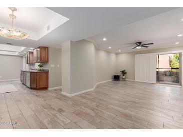 Spacious living room with wood-look tile floors and access to a balcony at 12212 N Paradise Village S Pkwy # 343, Phoenix, AZ 85032