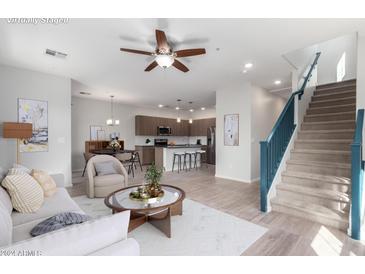 Bright living room with modern furniture and a view of the kitchen and staircase at 2360 E Hidalgo Ave, Phoenix, AZ 85040