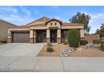 House exterior featuring a two-car garage, neutral color scheme, and nicely landscaped front yard at 282 E Bartlett Way, Chandler, AZ 85249